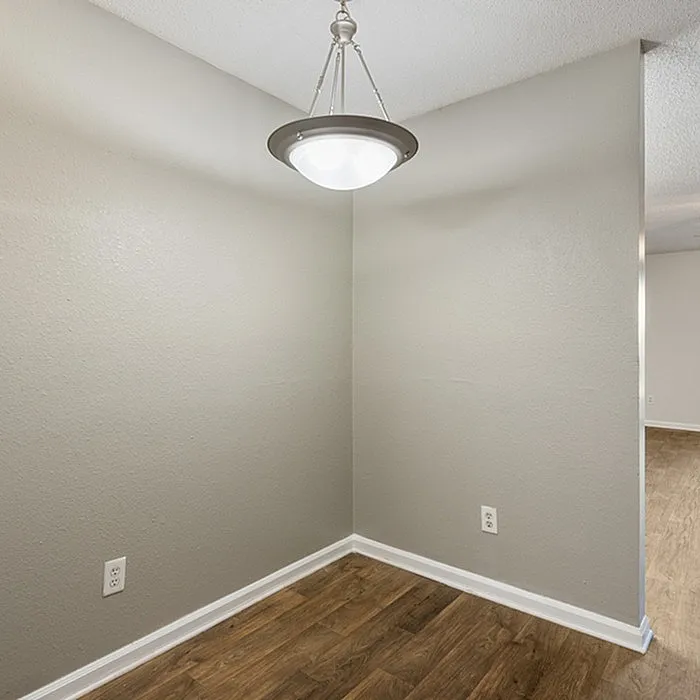 Charming alcove with sleek wood flooring and modern pendant light, offering a cozy space for creative designs.