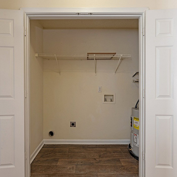 Efficient laundry area with utility hookups and sleek wood flooring, perfect for modern living.