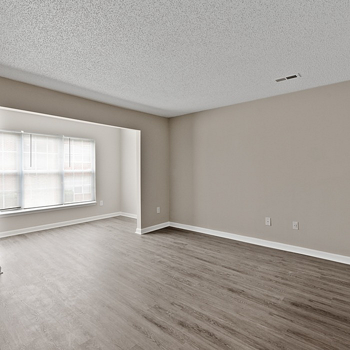 Bright and spacious living room with elegant wood flooring and large windows for natural light.