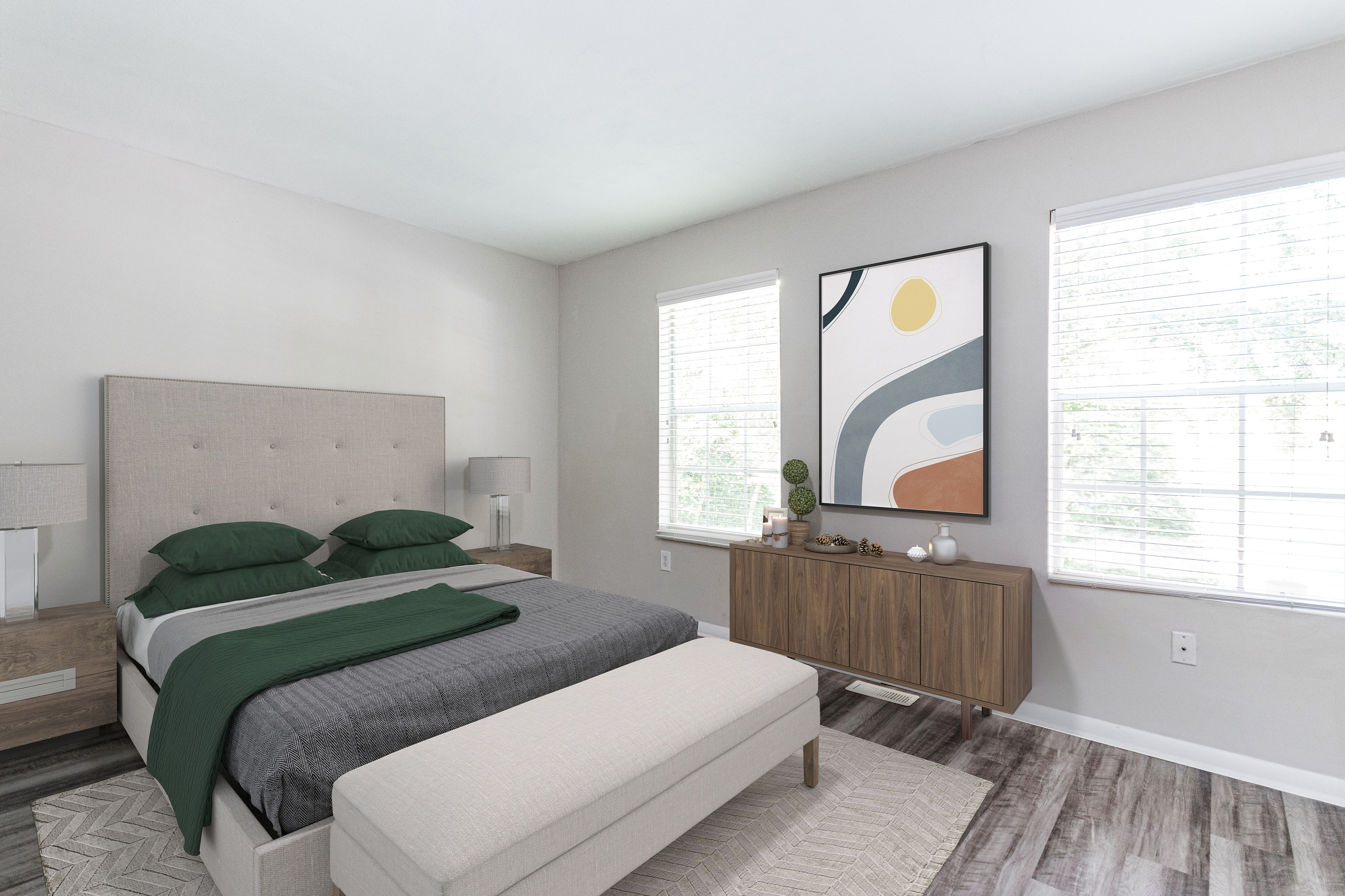 Spacious room with elegant dark wood flooring and soft neutral walls, enhanced by a ceiling fan for comfort.