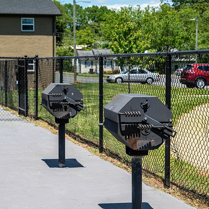 Inviting outdoor space with modern barbecue grills and a scenic fenced backdrop, ideal for entertaining.