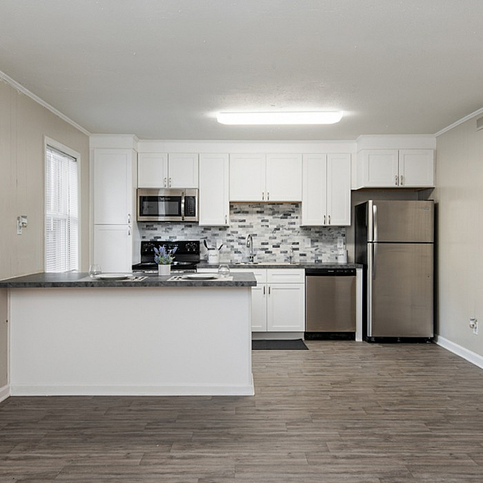 Modern kitchen with sleek stainless steel appliances, elegant white cabinetry, and stylish tile backsplash.