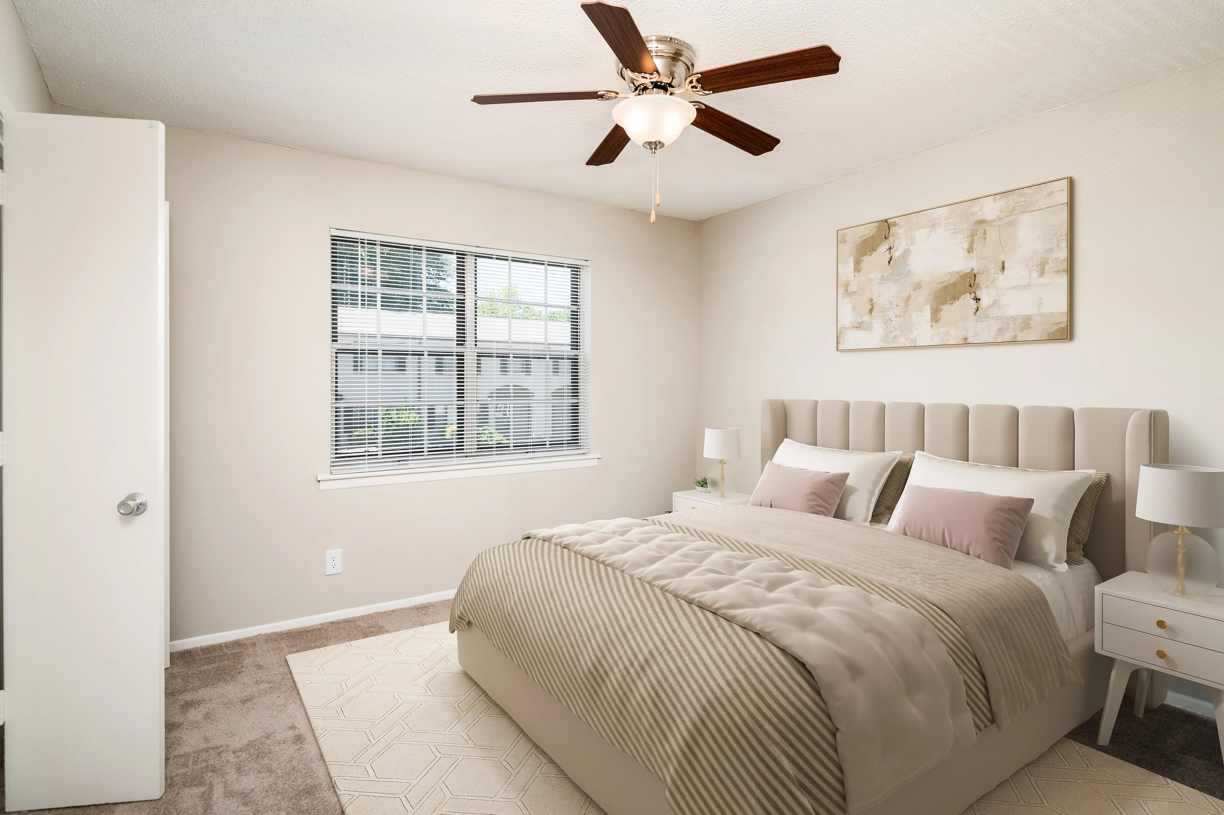 Elegant bedroom featuring a cushioned headboard bed, large window with garden view, and modern ceiling fan.