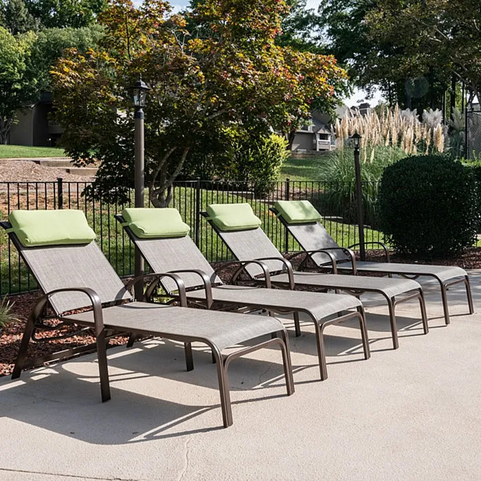 Inviting outdoor relaxation area with four stylish lounge chairs, perfect for soaking up the sun in a serene garden setting.