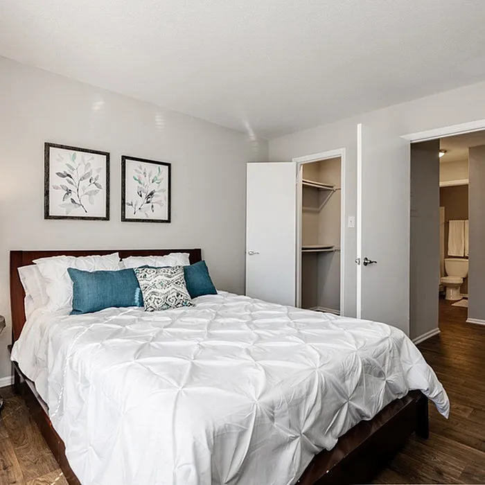 Elegant bedroom with plush bedding, modern decor, and spacious walk-in closet.