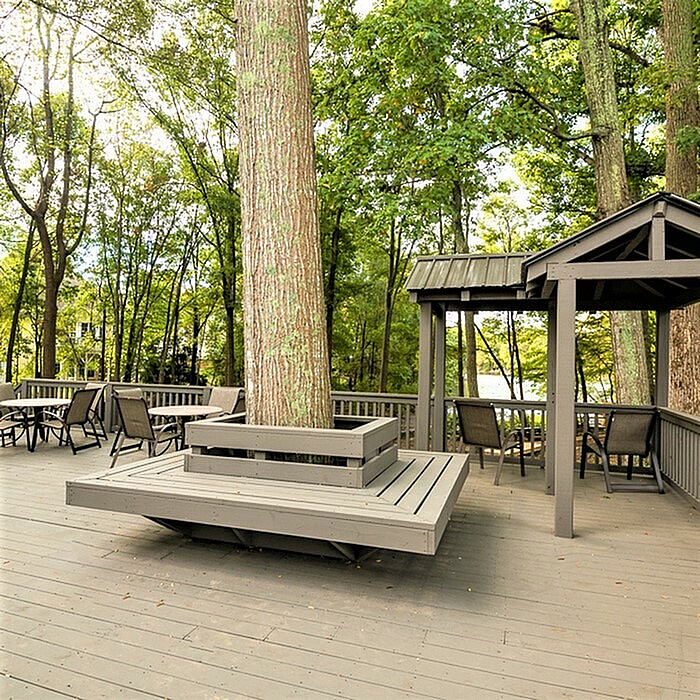 Stunning outdoor patio with modern seating, nestled among lush trees, offering serene nature views.