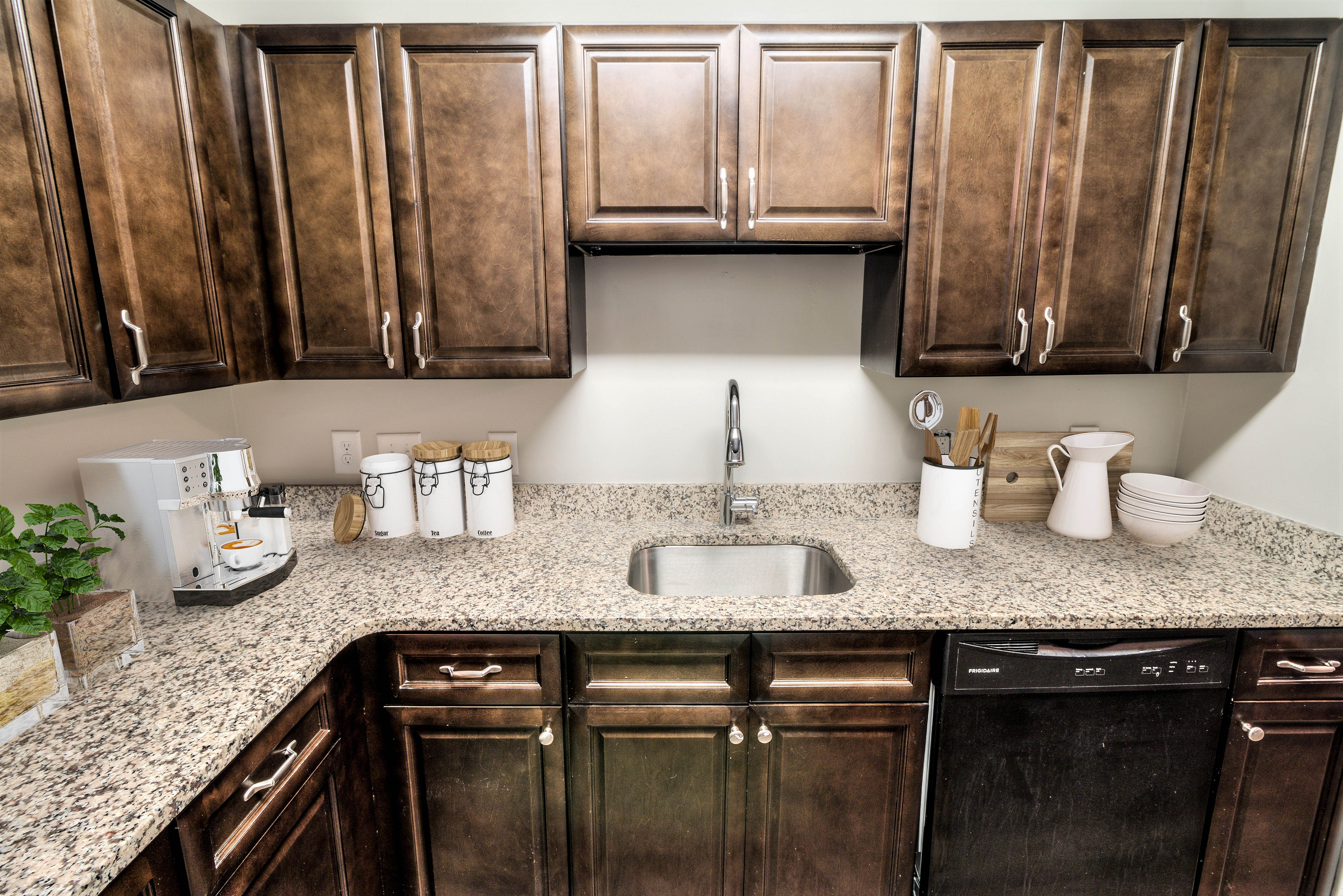 Modern kitchen with elegant wooden cabinets, sleek granite countertops, and high-end appliances, perfect for culinary enthusiasts.