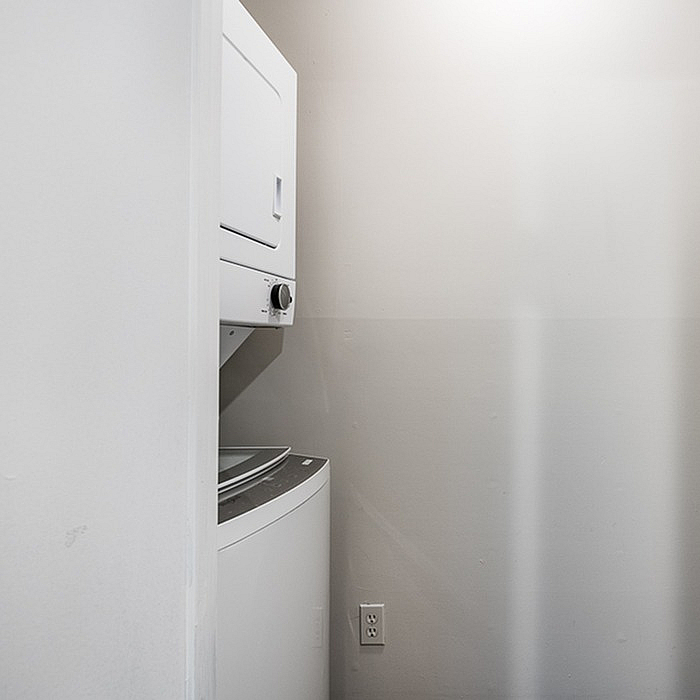 Compact laundry area with sleek stacked washer and dryer in a modern apartment.