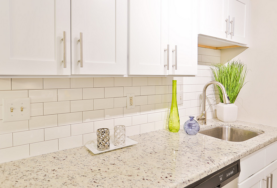 Contemporary kitchen design with elegant white cabinetry, sleek granite countertops, and stylish decor accents.