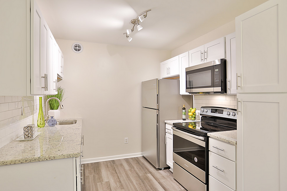 Modern kitchen featuring sleek stainless steel appliances, elegant granite countertops, and stylish white cabinetry for a sophisticated look.