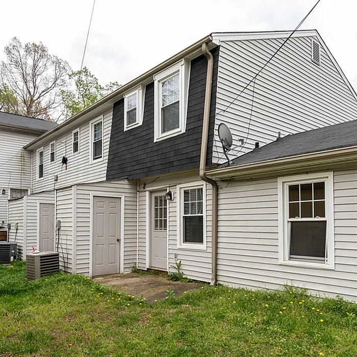 Charming two-story townhouse with modern siding and private backyard, perfect for comfortable living.