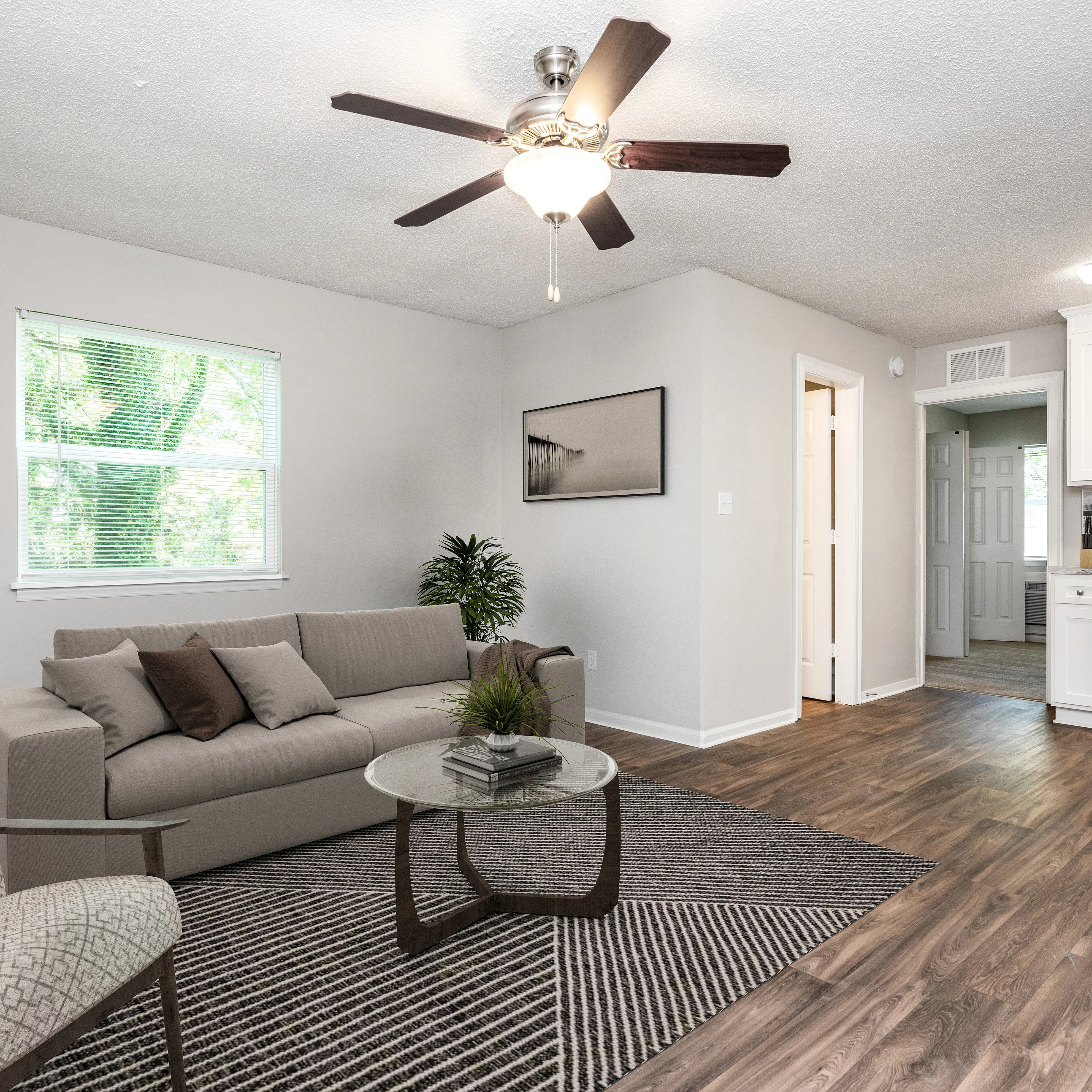 Bright, modern living room featuring stylish decor, elegant wooden flooring, and abundant natural light from large window.