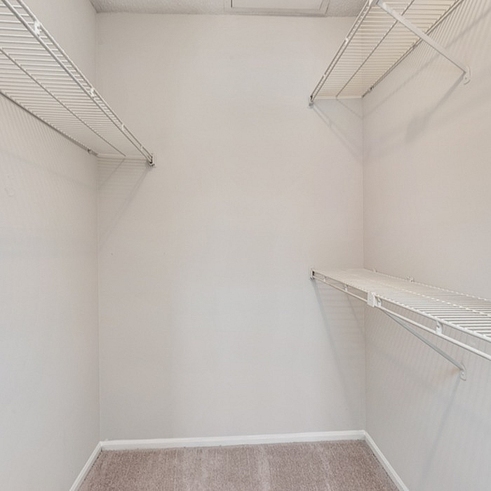 Spacious walk-in closet with ample shelving, offering organized storage solutions.