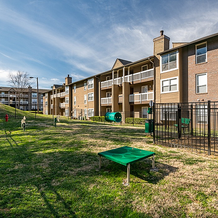 Sunlit pet-friendly apartment community with spacious balconies, lush green play area, and modern amenities.