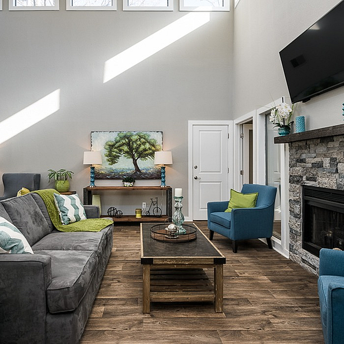 Bright, inviting living room with vaulted ceilings, elegant stone fireplace, and stylish modern furnishings.