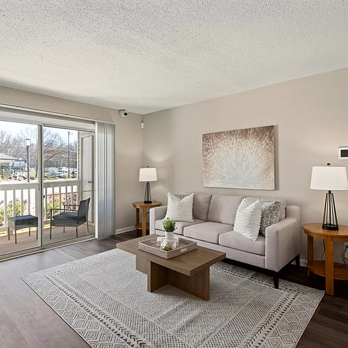 Inviting living room with a cozy sofa and elegant decor opening to a sunny balcony view.