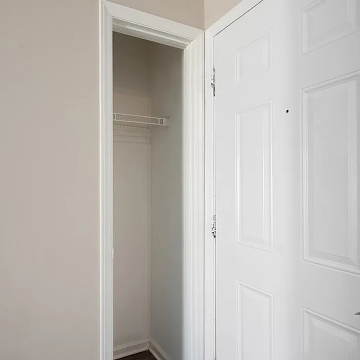 Bright and inviting entrance showcasing a sleek, modern interior closet with ample storage space.