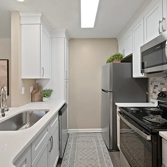 Modern kitchen with sleek stainless steel appliances, elegant cabinetry, and a stylish backsplash design.