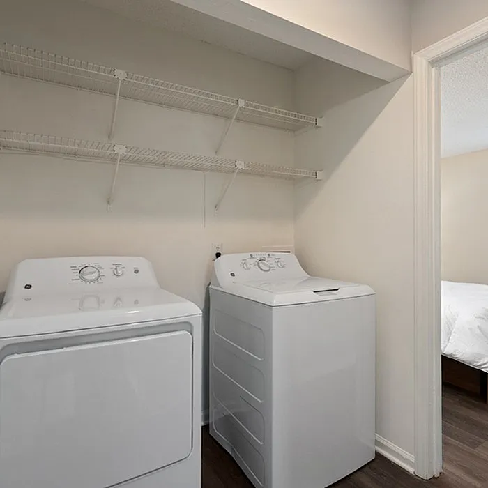 Modern laundry area featuring a sleek washer and dryer set, complemented by open shelving for effortless organization.