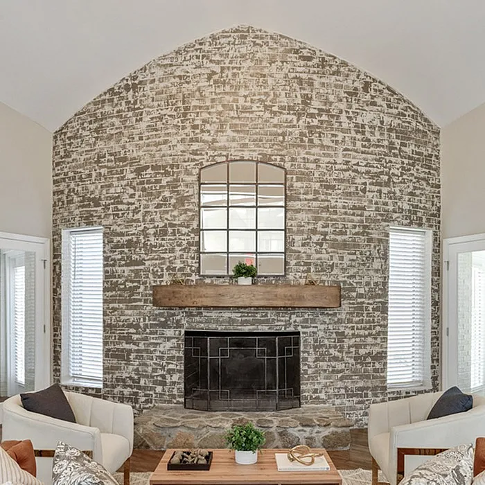 Charming living room with a rustic brick accent wall, stylish fireplace, and elegant seating for cozy living.