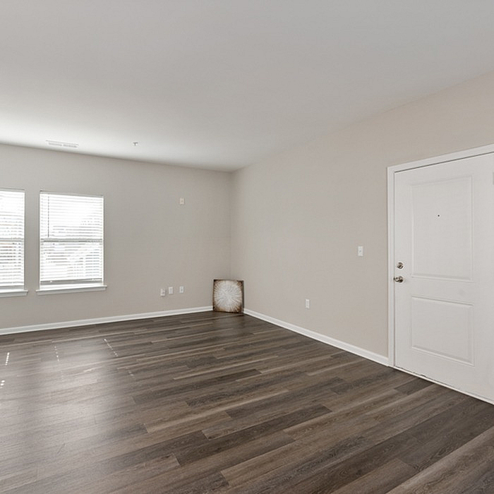 Bright and inviting living space with modern wood flooring and ample natural light, creating a warm and welcoming atmosphere.