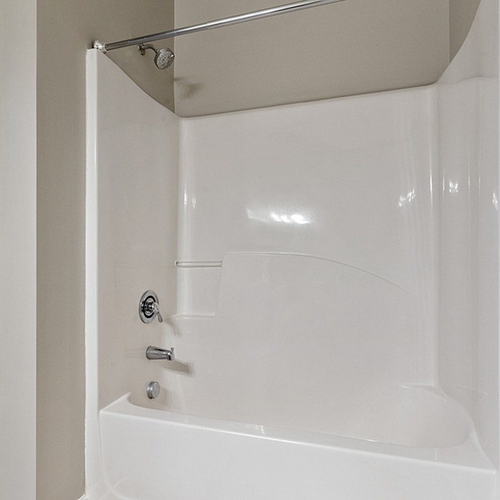 Modern bathtub with sleek white finish and elegant showerhead, perfect for a relaxing bathroom retreat.
