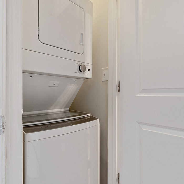 Compact laundry closet featuring a modern stackable washer and dryer set, perfect for efficient living spaces.