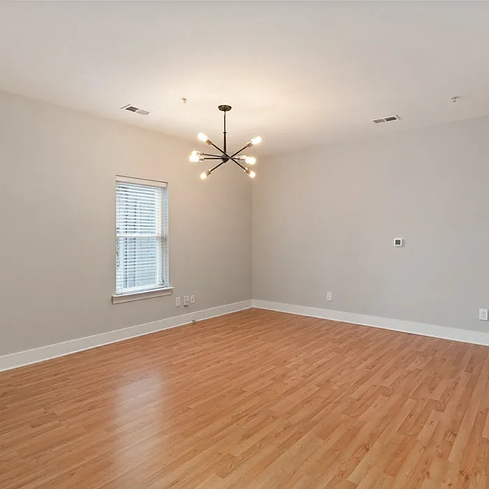 Spacious and bright living area with elegant wooden flooring and modern chandelier.