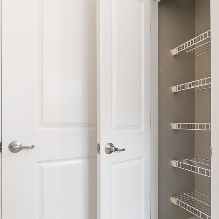 Bright double door storage closet with metal shelving, offering ample space for organization.