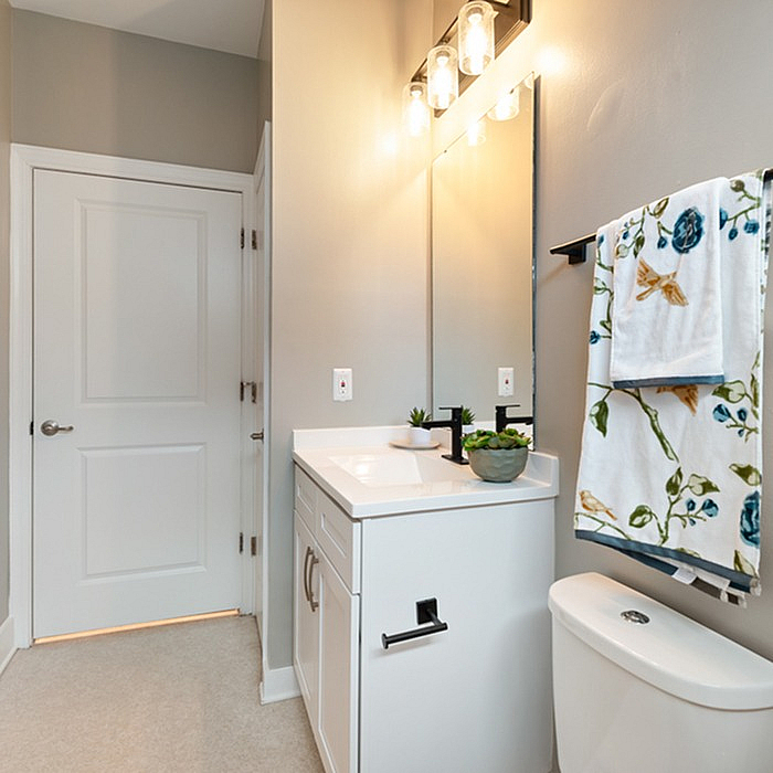 Chic and modern bathroom with elegant lighting, sleek vanity, and stylish floral accents creating a refreshing ambiance.