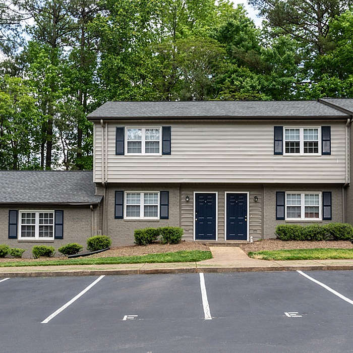 Charming two-story duplex surrounded by lush greenery, featuring plentiful natural light and inviting curb appeal.