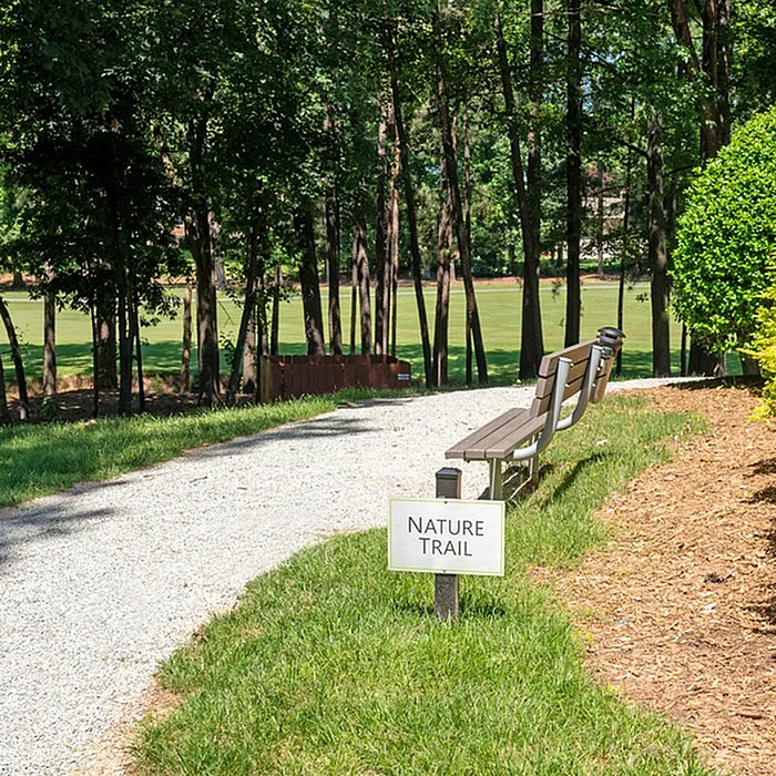 Inviting nature trail with scenic wooded views and peaceful benches, perfect for relaxation in a serene environment.