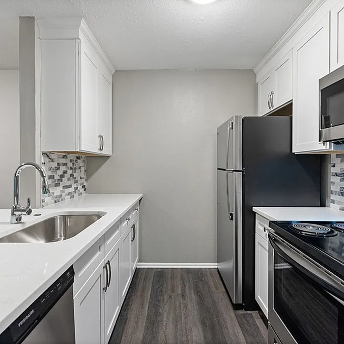 Modern kitchen with sleek stainless steel appliances, elegant white cabinetry, and stylish tile backsplash.