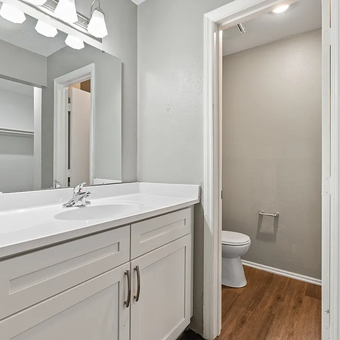 Elegant bathroom with modern vanity, large mirror, and stylish lighting.