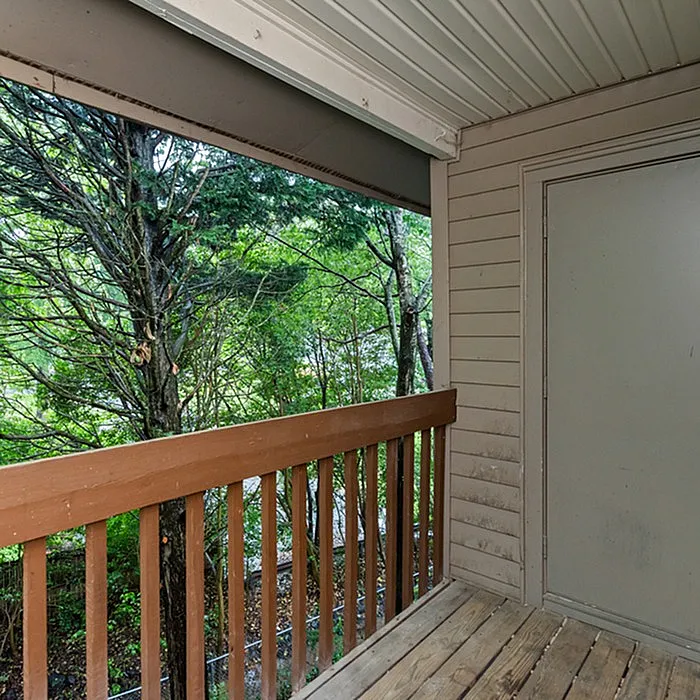 Charming balcony retreat with wooden railing overlooking lush greenery for a peaceful outdoor escape.