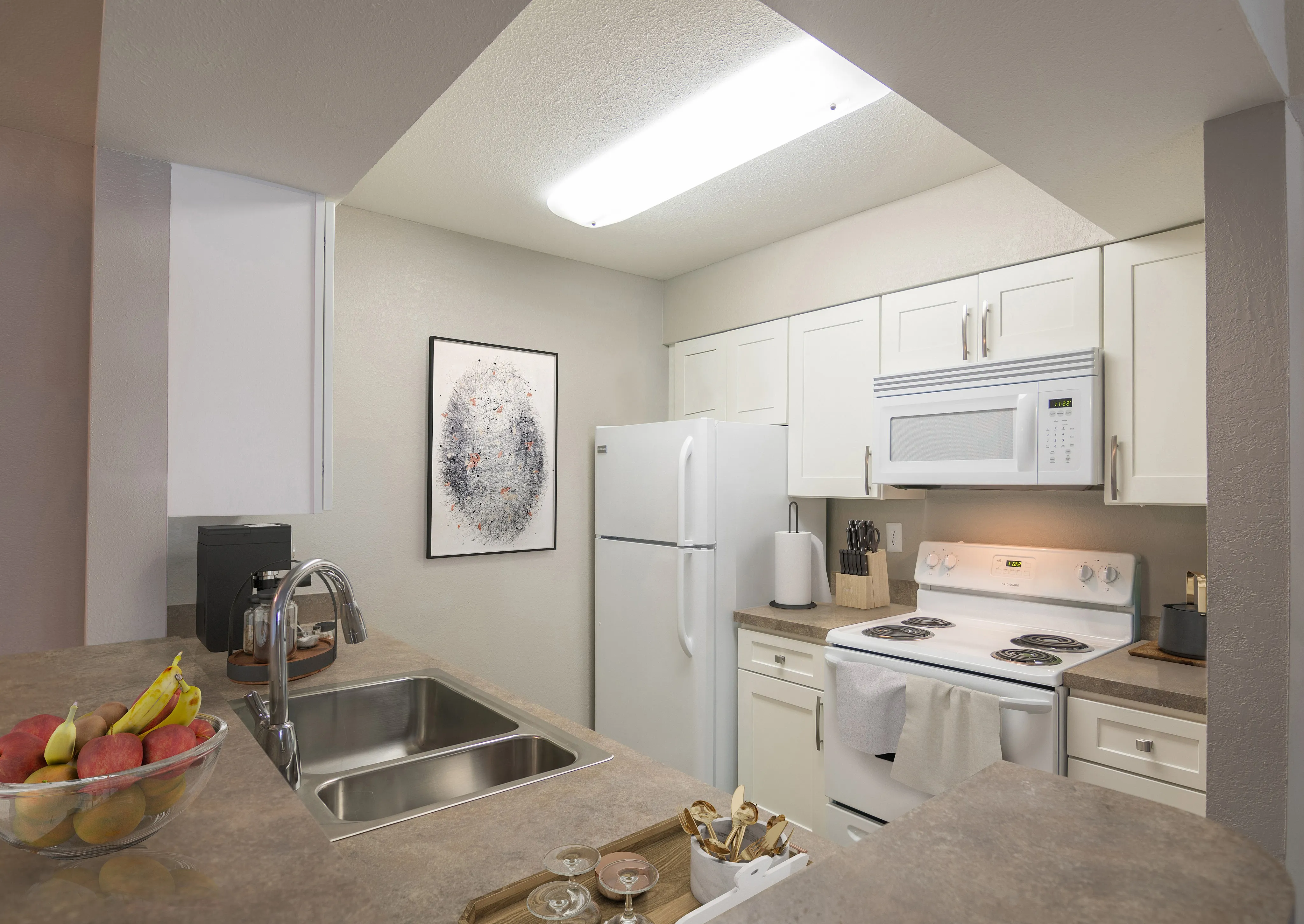 Modern kitchen with sleek countertops, stainless steel appliances, and stylish white cabinetry, perfect for culinary enthusiasts.