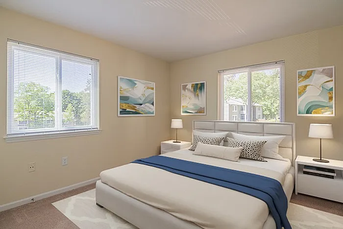 Bright and inviting bedroom with modern decor, showcasing a plush bed, elegant wall art, and large windows offering scenic views.