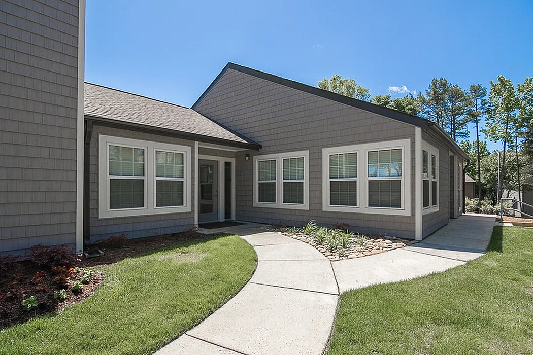 Charming modern home exterior with a welcoming path, lush greenery, and elegant architectural details.