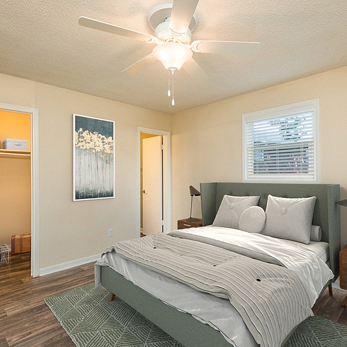 Inviting bedroom with cozy bedding, ceiling fan, and stylish decor, adjacent to a walk-in closet and bathroom.
