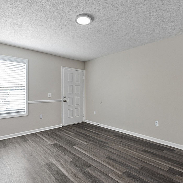 Bright, modern room with sleek gray flooring and natural light streaming through a large window.