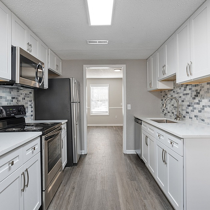 Bright modern kitchen with sleek stainless steel appliances and elegant white cabinetry.