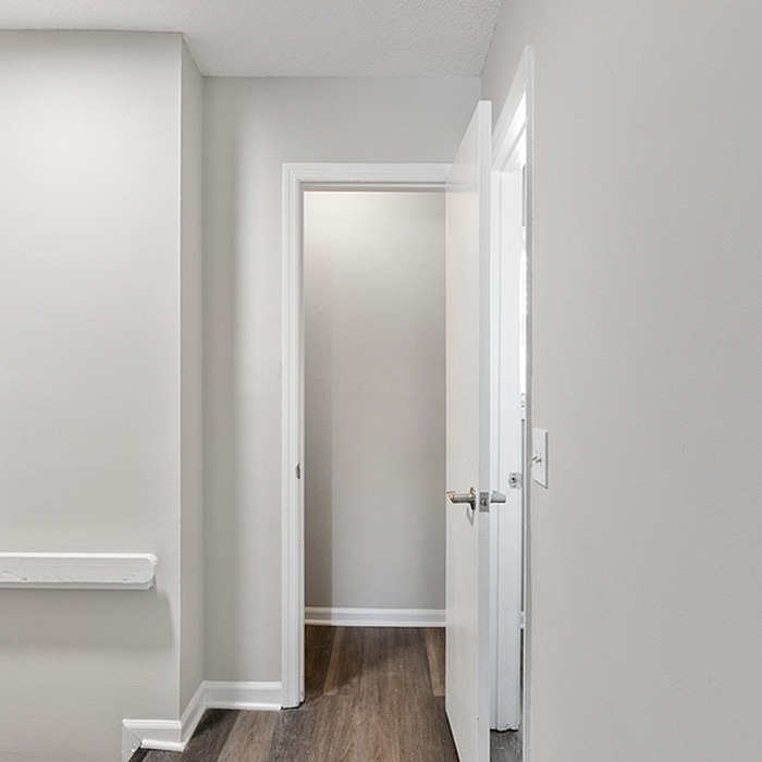 Modern hallway entrance with sleek white doors and elegant wood flooring, exuding minimalist charm.