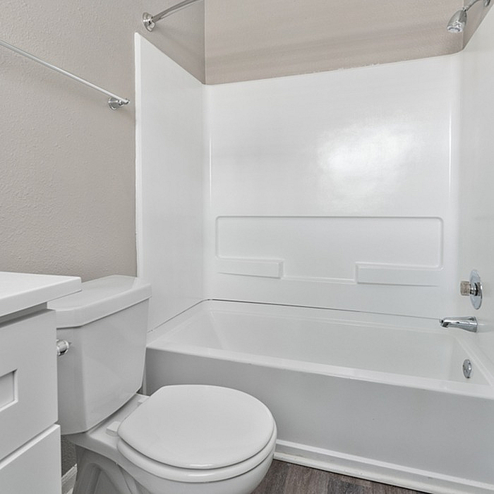 Bright and modern bathroom featuring a sleek bathtub and pristine white fixtures.