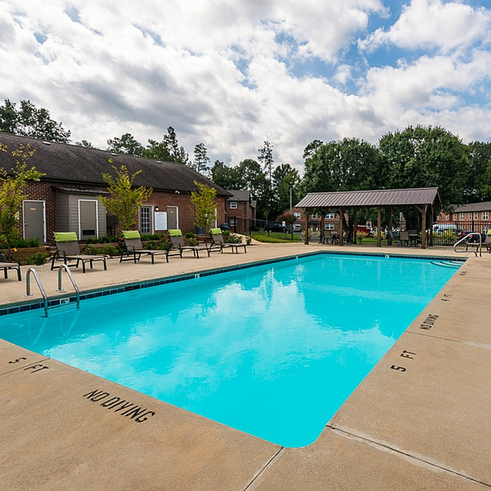 Inviting poolside retreat with sleek lounge chairs and lush greenery, perfect for relaxation and leisure.