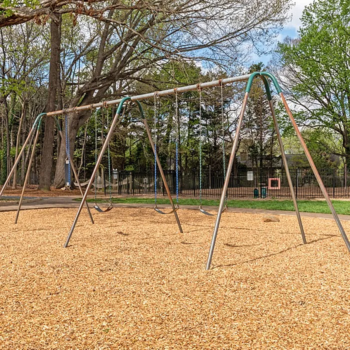 Inviting playground swings set amidst lush greenery, perfect for family enjoyment and outdoor fun.