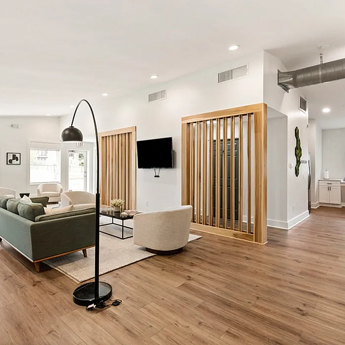Modern apartment living room with sleek wooden flooring, stylish furniture, and bright natural lighting offering a welcoming ambiance.