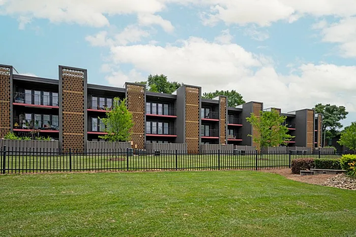 Modern apartment complex with stylish architecture, spacious balconies, and lush green surroundings.