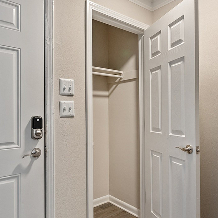 Inviting entryway with a sleek closet featuring a modern door and smart lock, perfect for contemporary living.