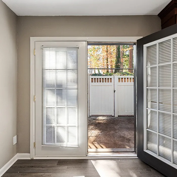 Bright and inviting interior view featuring French doors opening to a private outdoor space, offering natural light and seamless indoor-outdoor living.