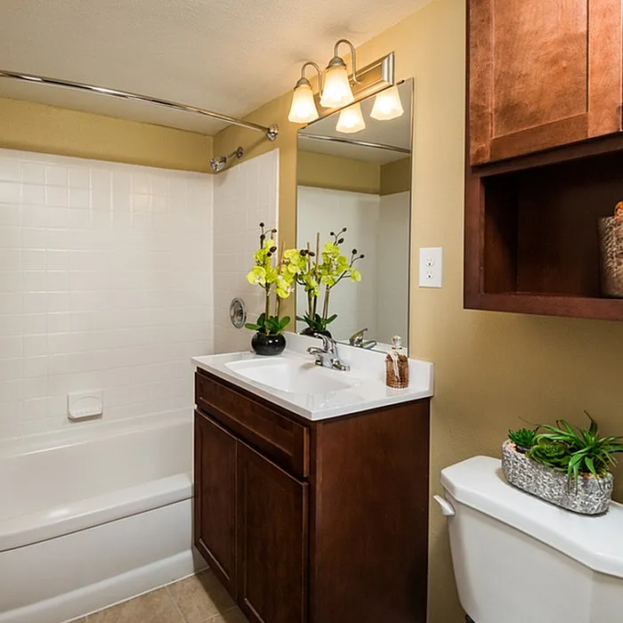 Elegant bathroom with dark wood vanity, sleek white fixtures, and vibrant floral accents for a fresh touch.